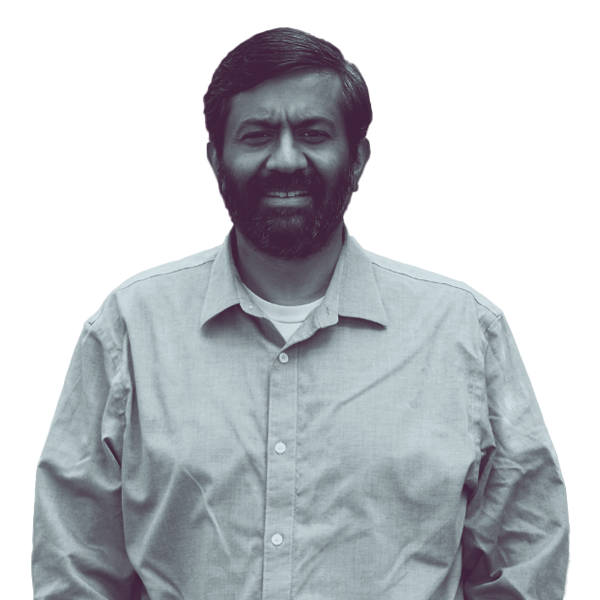 A black and white portrait of Anand Patel of PA HD-142 from the waist up, smiling and looking into the camera.