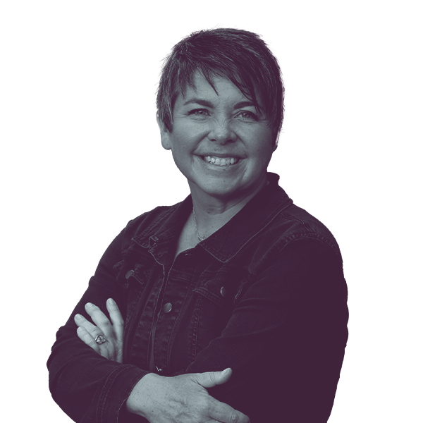 A black and white image of Betsy Coffia of Michigan House district one hundred and three from the waist up, smiling and looking into the camera.