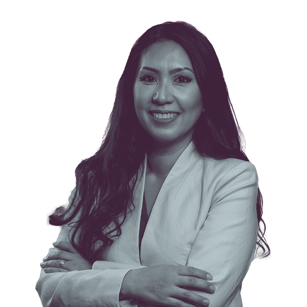 A black and white image of Mai Xiong of Michigan House district thirteen from the waist up, smiling and looking into the camera.