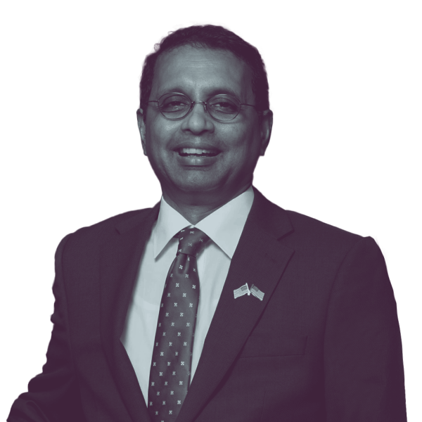 A black and white waist-up portrait of Kannan Srinivasan, candidate for Virginia Senate District 32, smiling and looking into the camera.