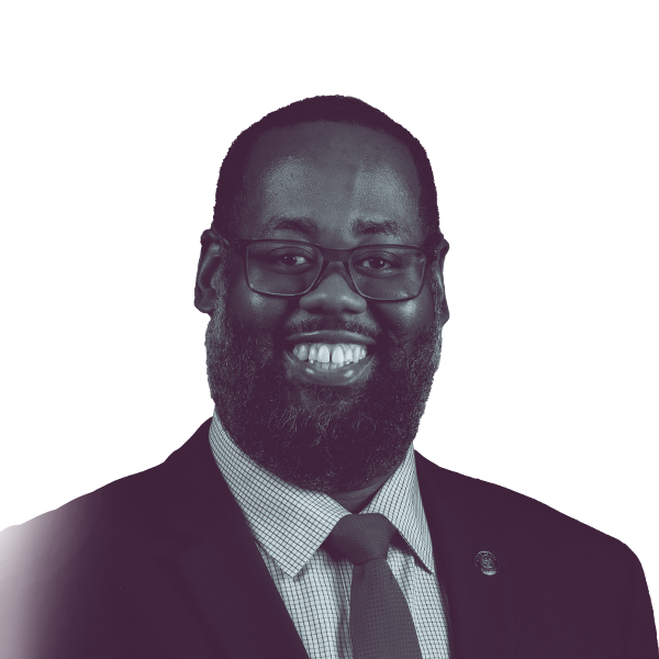 A black and white portrait of Reginald Jackson, Democratic candidate for Mississippi Senate District 11, smiling and looking into the camera.