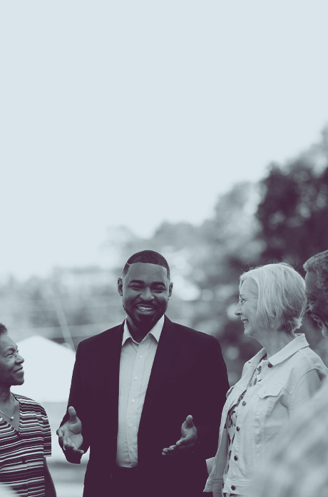A black and white image of Del. Josh Cole speaking with two people.